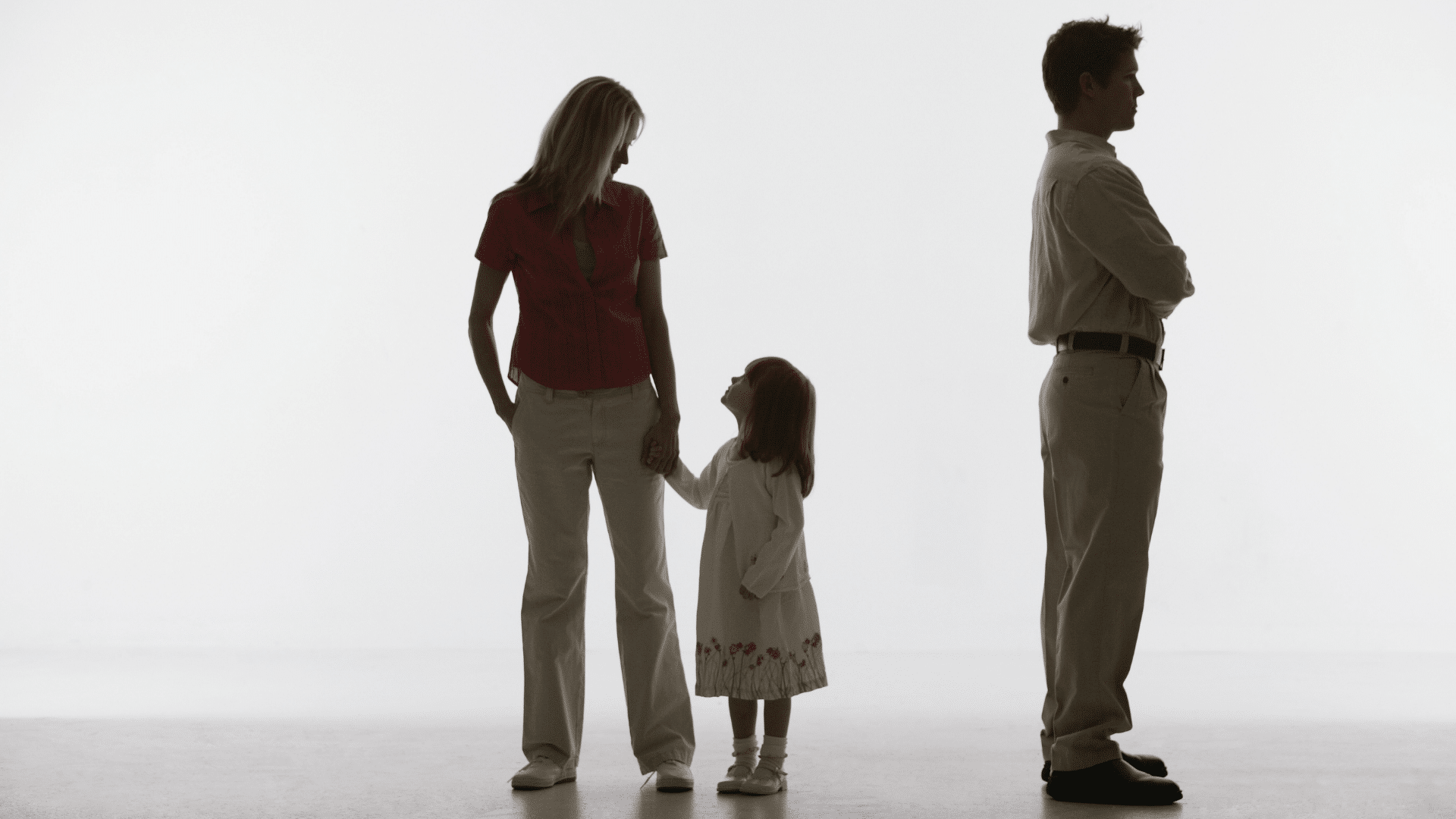 Family standing apart, child in between.